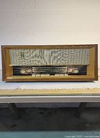 Full frontal view of Stern Bros Bolero tube radio showing wooden housing and fabric speaker cover.