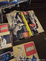 Top of table showing open box of LEGO set 918 and two other yellow-fronted Classic Space boxes