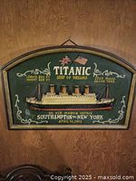 Close shot of the vintage Titanic wall plaque showing the 3D ship and painted details.
