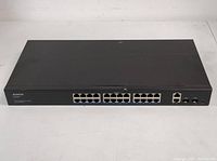 Front view of the Aumox 28-port gigabit PoE switch showing 24 PoE Ethernet ports and additional uplink ports with Aumox branding.