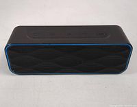 Front view of Zoeetree Bluetooth speaker showing black body with blue trim and control buttons on top.
