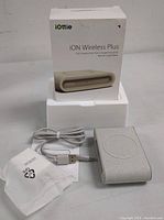 Photo showing wireless charging pad, USB cable, original box and protective sleeve.
