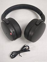 Front view of black Sennheiser 350BT headphones showing ear cups and headband with USB charging cable below.