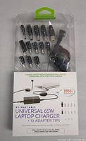 Front view showing the universal charger and 13 different adapter tips in sealed packaging.