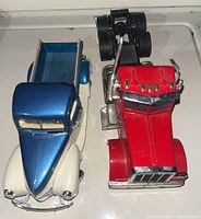 Front and side view of both diecast model trucks, showing detail on the 1940 Ford Pickup truck and Peterbilt transport truck including colors and condition.