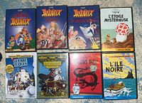 Full front view of all 8 DVD covers featuring Asterix, Tintin, Baron Munchausen and Guerre des Tuques with colorful illustrations and titles in French.