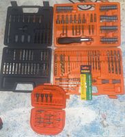 Overview photo showing three cases with assorted drill and screwdriver bits of various sizes and types laid out on floor.