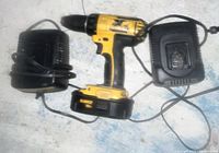 DeWalt cordless drill model DCD760 with battery attached, showing wear. Two black DeWalt battery chargers beside it.