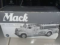 Front and top view of original box showing the image of the Mack 1960 B-Model pumper model truck and product branding with some box wear.