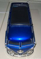 Top view of blue 1962 Volkswagen Bus die cast model with a black sunroof visible.