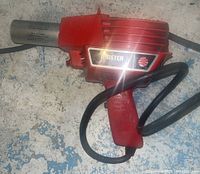 Front and side view of the red Master Appliance Corp heat tool, showing the label 'MASTER' and power cord.