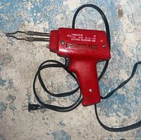 Red Pemco electric soldering gun with visible branding and specifications on side. 120V 100W power markings.