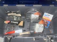 Overview of items placed inside the toolbox showing timers, polishing paste, nails, screws, and straps with nails