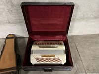 Accordion displayed open in black hard case with red velvet lining
