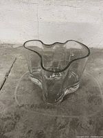 Side view of clear glass vase with undulating free-form rim