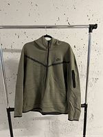 Front view of olive green Nike full-zip hoodie jacket with zipper and chest logo