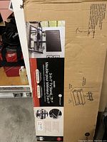 Cardboard box showing the packaging of the 3-in-1 TV Stand by Philux with product details and images.