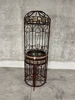 Front view of wrought iron bar cabinet closed, showing dome top and tile insets.