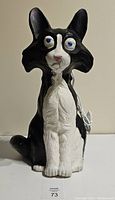 Front view of vintage black and white cat blow mold showing sitting pose, painted details and condition.