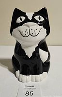 Front view of modern cat-shaped ceramic vase, black and white, with smiling face and painted features.