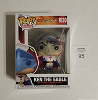Front view of boxed Ken The Eagle Funko Pop figure with visible packaging and clear window showing figure.