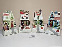 Four Hallmark Chorus Musical Village Christmas houses arranged in a row showing all decorations and details.