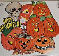 Lot of seven vintage-style Halloween diecut paper decorations on a white surface with a measuring ruler showing size.
