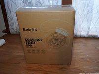 Photo of unopened brown cardboard box with printed branding and product name 'Belmint Press Escape Compact Foot Spa'.