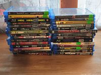 Two stacks of 29 Blu-ray movie cases showing front spines, with visible titles such as The Meg, Inception, The Conjuring, Moon, Jurassic Park, Bohemian Rhapsody, Watchmen, and Requiem.
