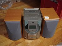 Front view of JVC FS-V5 stereo system showing central unit and two wooden speakers