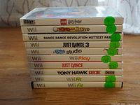 Stack of 11 Nintendo Wii game cases showing the titles on spine with condition varying stickers