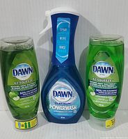Front view of two green Dawn EZ-SQUEEZE Apple Blossom dish soap bottles and one blue Dawn Platinum Powerwash spray bottle showing product labels and volumes.