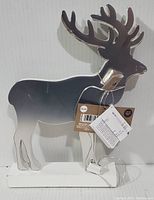 Front and side view of silver metallic reindeer Christmas decoration standing on white base with price and product tags attached, showing details of attached light bulb and clean condition.