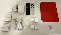 Top view of all items including remotes, mouse, headphones, adaptors, Square reader, and iPad cover.