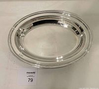 Top view of oval silver Christofle serving dish showing polished surface and raised rim detail.