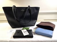 Front view of Kate Spade tote with two wallets and dust bag