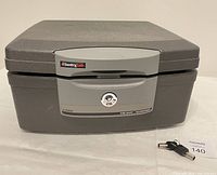 Front view of closed Sentry Safe fireproof waterproof lockbox with two keys displayed in front