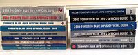 Spine view of fourteen Toronto Blue Jays Official Media Guides from years 1988, 1989, 1994, 1995, 1998-2000, 2002-2006, 2008, and 2011, showing consistent branding and good condition.