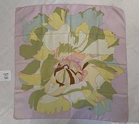 Full view of the square lavender silk scarf featuring a bold floral design in pastel green, yellow, cream and pink