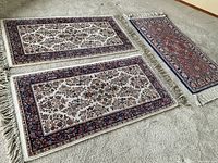 Three Karastan wool rugs laid out side-by-side showing two Ivory Sarouk pattern rugs and one Serapi pattern rug.
