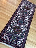 Full view of runner rug laid on wood floor showing entire tribal geometric pattern and borders