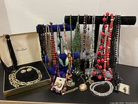 Multiple necklaces displayed on velvet stands with boxed set and loose earrings and pendant