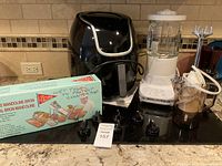 Overview photo showing all four items: PowerXL Vortex Air Fryer, KitchenAid mixer, Bron Mandoline slicer box, and Bamix immersion blender with container and blades.