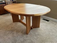 Full view of oval dining table showing tabletop and V-shaped pedestals