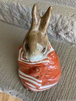 Close-up of vintage Beatrix Potter Peter Rabbit figurine wearing an orange coat with white stripes, glazed terracotta, 3-3/4 inches tall