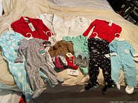 All clothing items laid out on bed showing variety of styles, colors, and sizes.