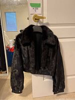 Front view of cropped jacket hanging on door