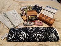 Various fabric organizers, fabric rolls, and small pouches arranged on a fabric surface.