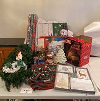 Full lot of Christmas decorations and boxed items arranged on table