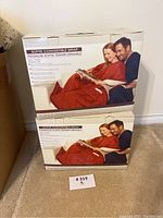 Pair of Softie Convertible Wrap boxed products stacked on carpeted floor showing front and side box views